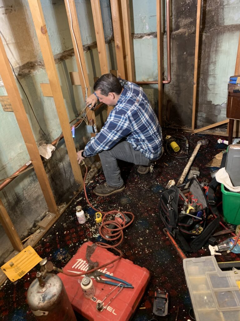 A plumber from HB Service Plumbing and Heating, working.